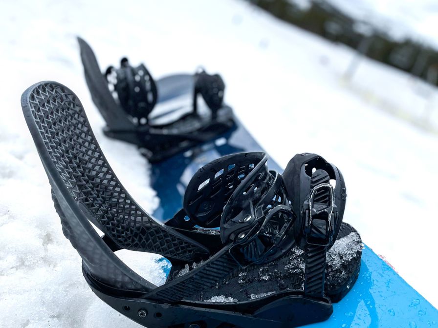 Snowboard with bindings in snow image.