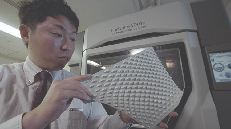 A man inspecting a 3d part with texture.