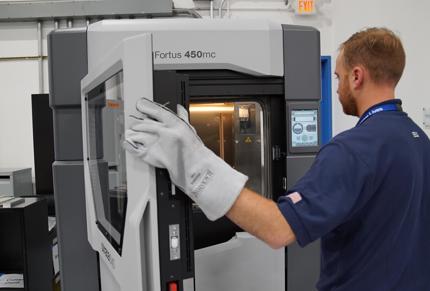 Worker closing Fortus 450mc 3D printer