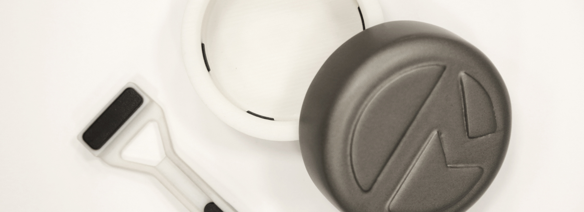 A grasping pincer (left) and packaging lid (right) –   3D printed with Stratasys PolyJet technology. Multimaterial 3D printing was used to create the white structural components and black rubber-like grips all in a single print.