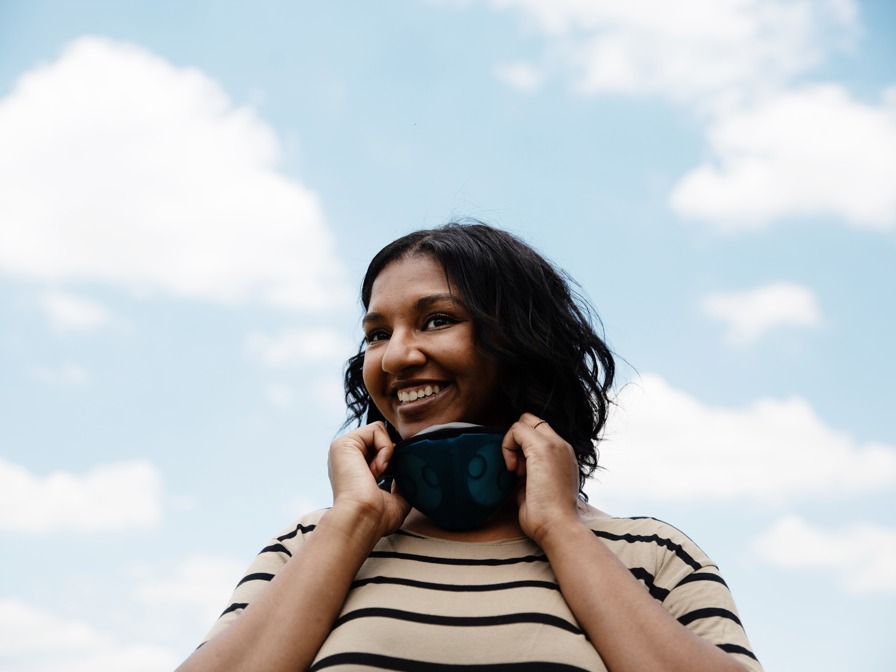 Woman smiles while wearing Breathe99 B2 respirator face mask.