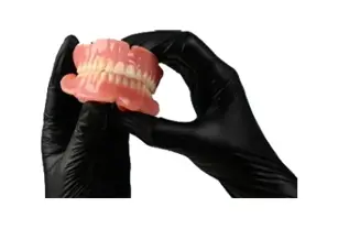 black-gloved-hands-holding-truedent-dentures