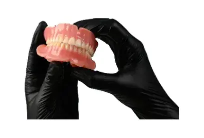 black-gloved-hands-holding-truedent-dentures