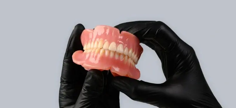 truedent-denture-held-by-gloved-hands