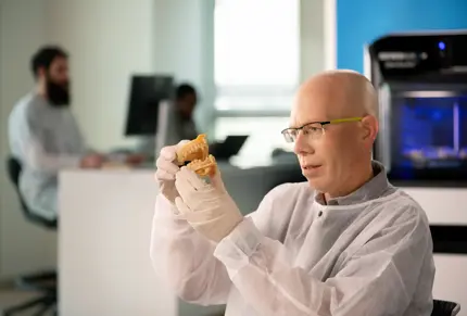 dental technician examining 3d printed denture model
